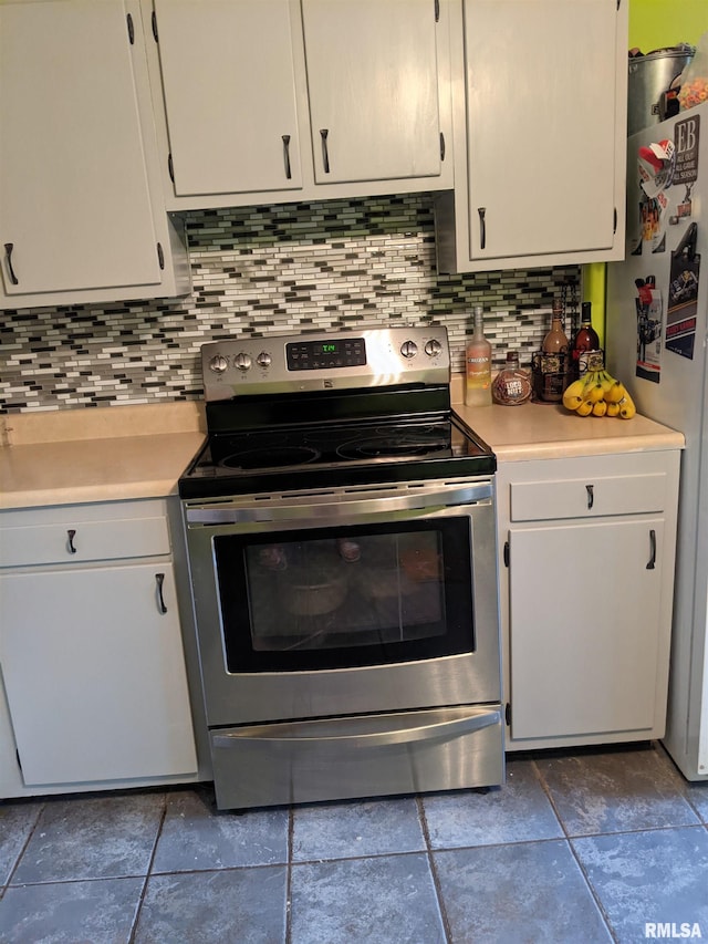 kitchen with white cabinets, decorative backsplash, white fridge, and stainless steel electric range