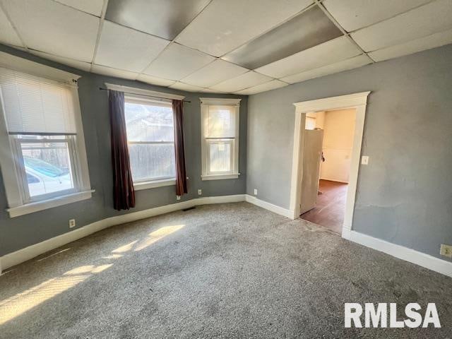 empty room with carpet and a drop ceiling