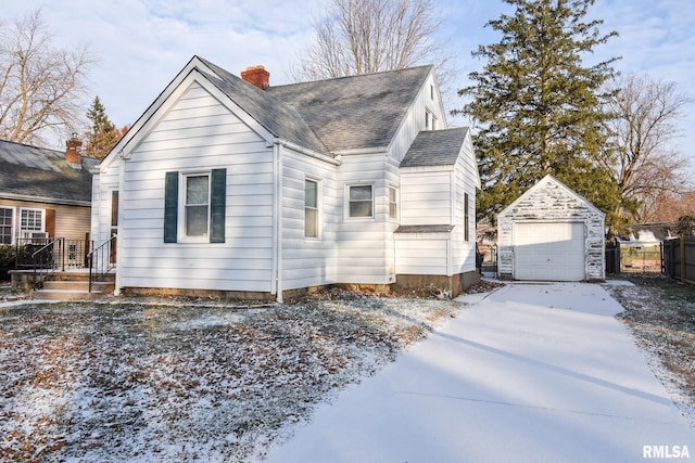 view of front of home featuring a garage and an outbuilding