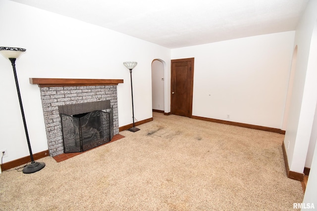 unfurnished living room with light colored carpet and a fireplace