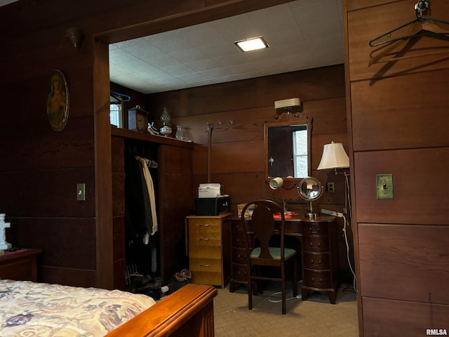 carpeted bedroom featuring wooden walls