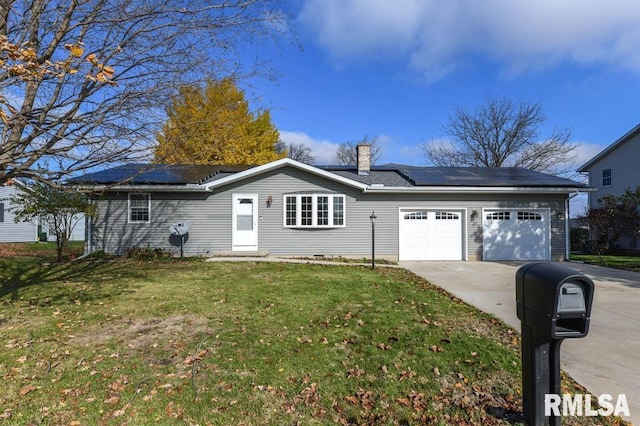 view of front of property featuring a garage, a front lawn, and solar panels