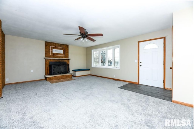 unfurnished living room with carpet, ceiling fan, and a brick fireplace