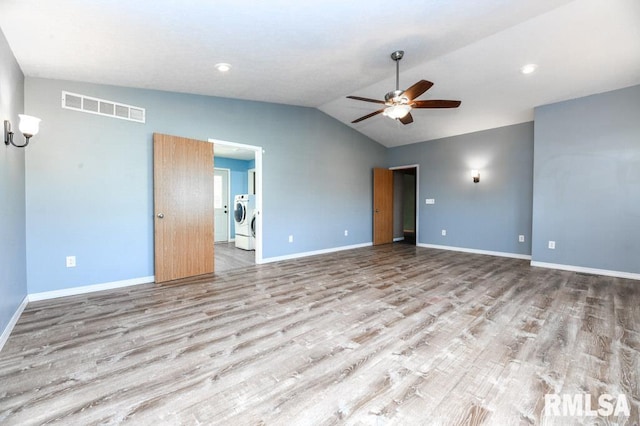 unfurnished room with ceiling fan, lofted ceiling, independent washer and dryer, and light hardwood / wood-style floors