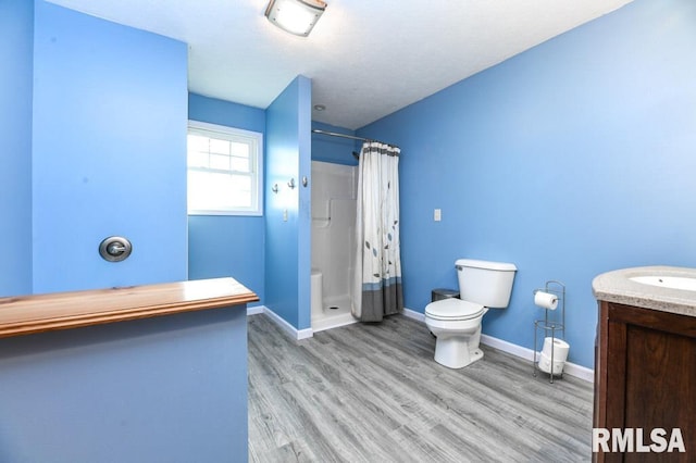 bathroom with hardwood / wood-style flooring, toilet, vanity, and a shower with curtain