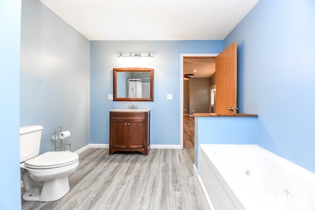 bathroom featuring vanity, a bath, wood-type flooring, and toilet