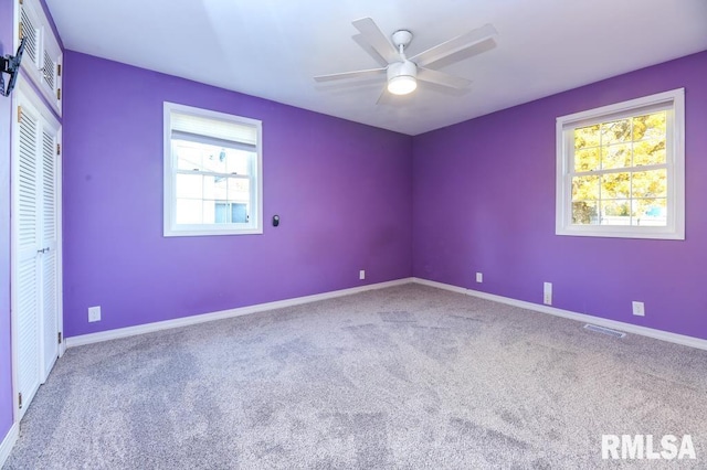 carpeted empty room featuring ceiling fan