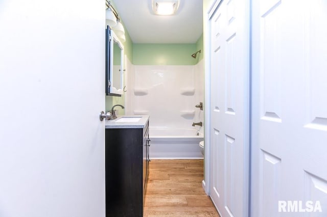 full bathroom featuring hardwood / wood-style flooring, vanity, toilet, and shower / bath combination