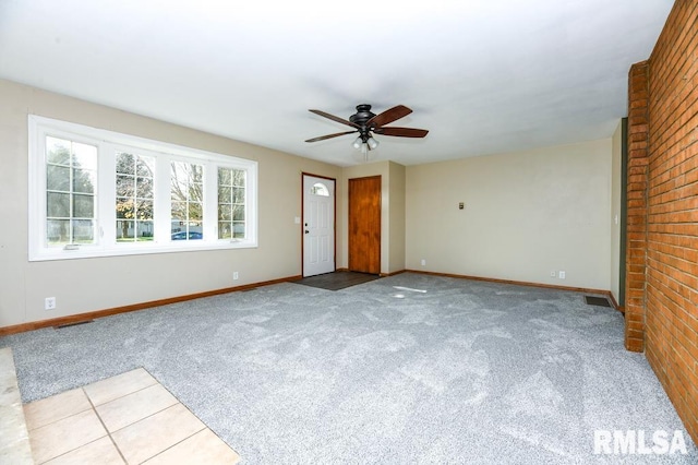 unfurnished living room featuring light carpet and ceiling fan