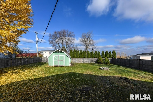 view of yard with a shed and a fire pit