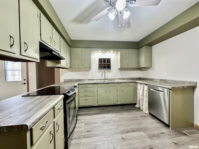 kitchen with sink, green cabinets, ceiling fan, stainless steel appliances, and light wood-type flooring