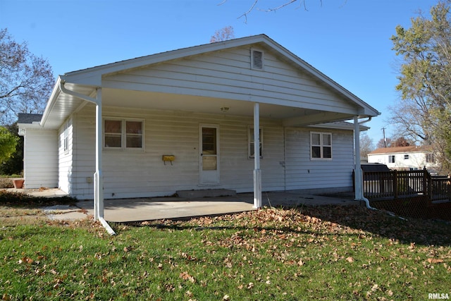 back of property featuring a patio area and a lawn