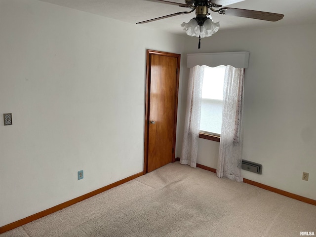 carpeted spare room with ceiling fan