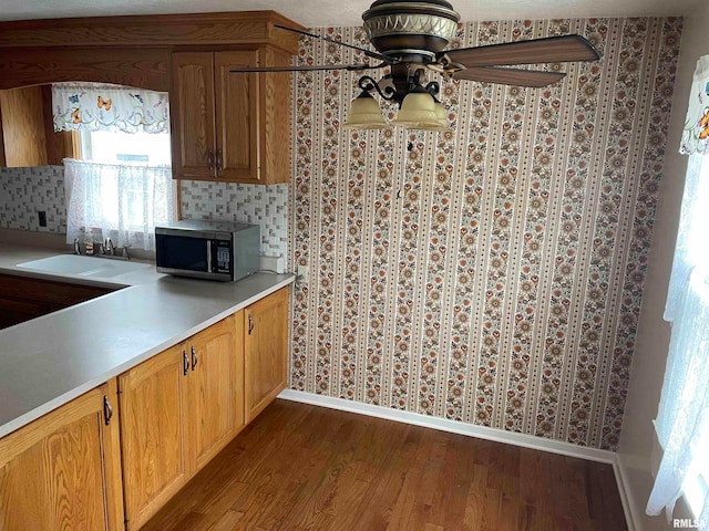 kitchen featuring wood-type flooring, ceiling fan, and sink