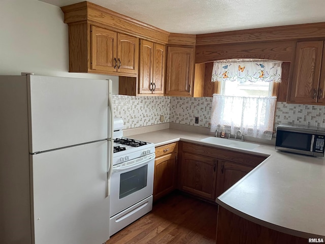 kitchen featuring tasteful backsplash, sink, dark hardwood / wood-style floors, and white appliances