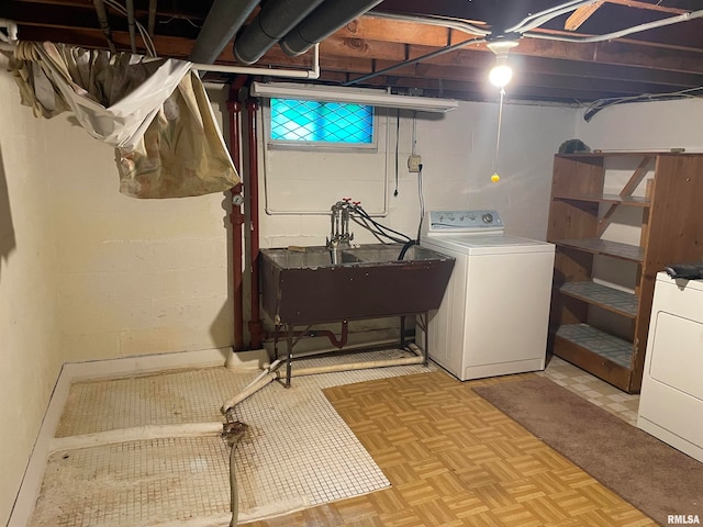 clothes washing area featuring washer / clothes dryer, sink, and light parquet flooring