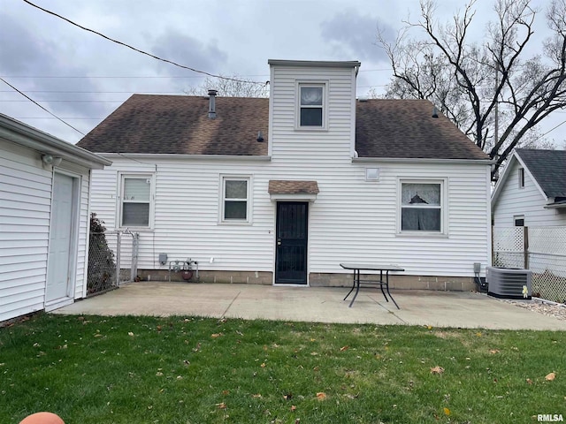 rear view of property with a patio, central air condition unit, and a lawn