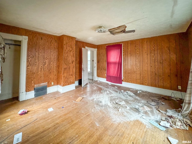 spare room featuring hardwood / wood-style floors and wood walls