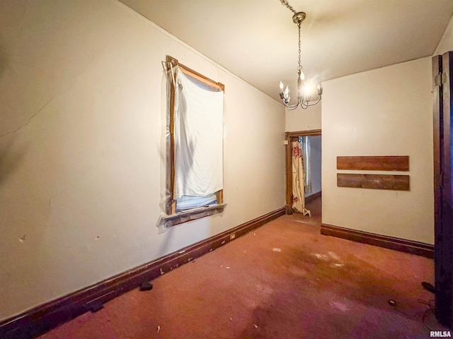 spare room with carpet floors and a notable chandelier