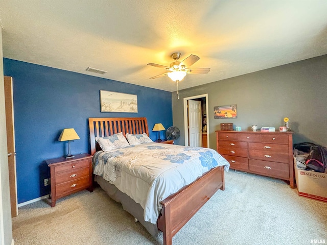 carpeted bedroom with a textured ceiling and ceiling fan