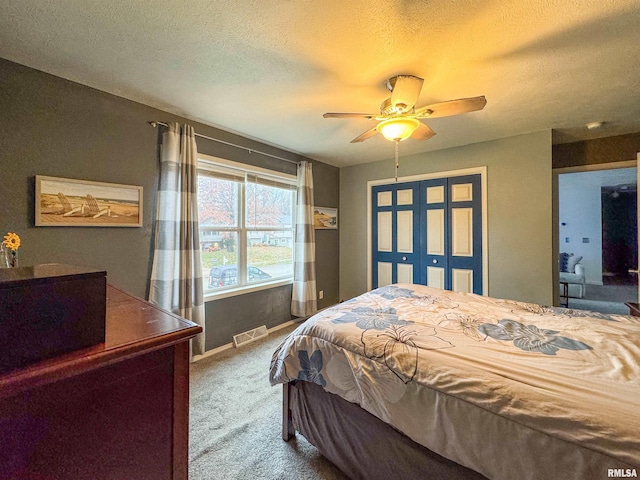 bedroom featuring carpet flooring, ceiling fan, and a textured ceiling