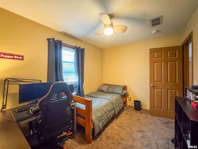 bedroom featuring ceiling fan, light colored carpet, and a textured ceiling