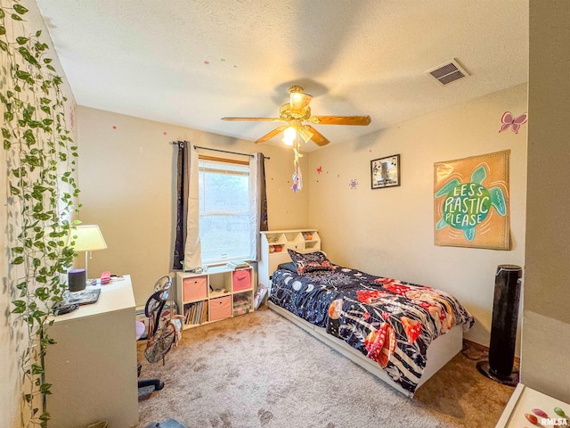 bedroom featuring carpet flooring, ceiling fan, and a textured ceiling