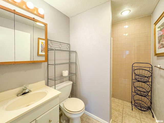 bathroom with tile patterned floors, vanity, a textured ceiling, and toilet