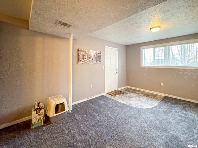 empty room with carpet floors and a textured ceiling