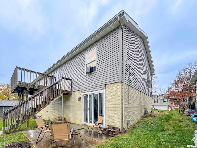 back of property with a wooden deck, cooling unit, an outdoor fire pit, a patio, and a lawn