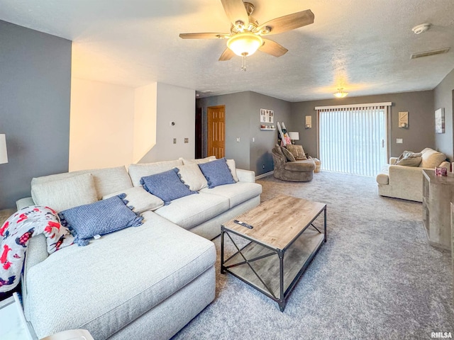 living room with carpet, ceiling fan, and a textured ceiling