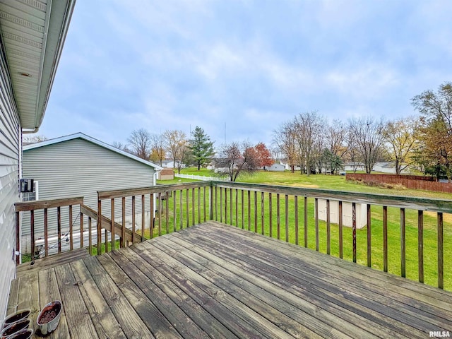 wooden deck featuring a lawn