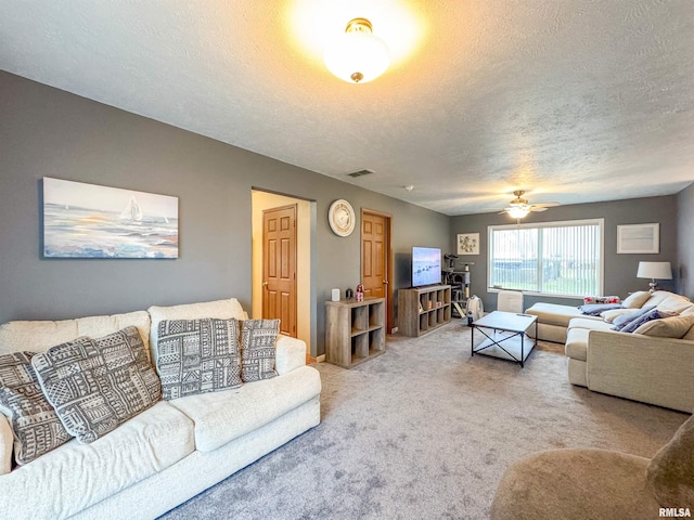 living room with ceiling fan, carpet, and a textured ceiling