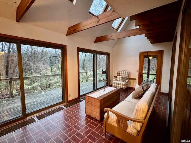 sunroom featuring lofted ceiling with skylight