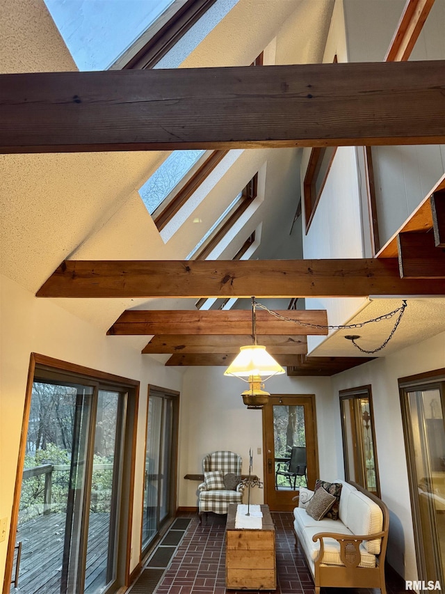 living area with high vaulted ceiling, brick floor, a skylight, baseboards, and beamed ceiling