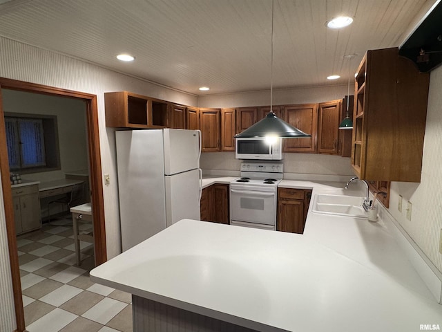 kitchen with decorative light fixtures, open shelves, light countertops, a sink, and white appliances