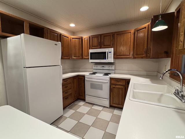 kitchen with recessed lighting, white appliances, a sink, light countertops, and pendant lighting