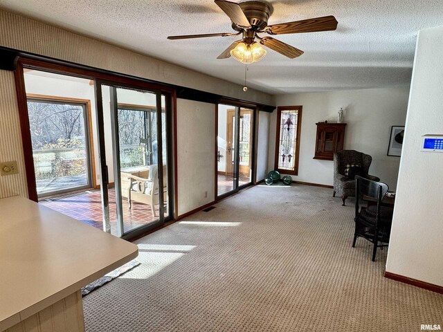 doorway featuring a textured ceiling, plenty of natural light, baseboards, and light colored carpet