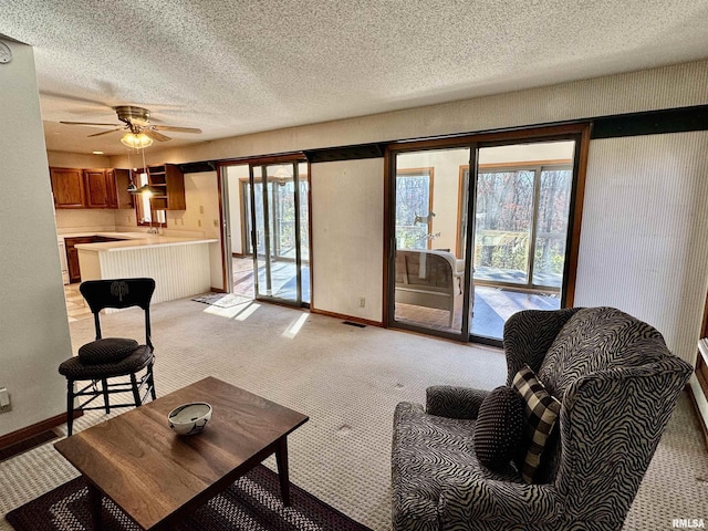 living room featuring baseboards, a textured ceiling, and light colored carpet