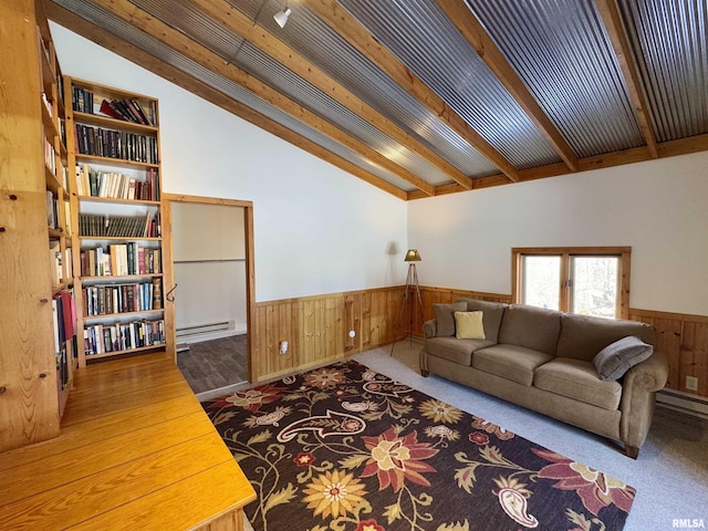 carpeted living area featuring a wainscoted wall, wooden walls, baseboard heating, and vaulted ceiling with beams