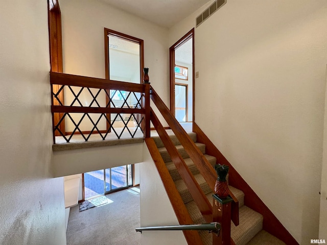 stairs with carpet flooring and visible vents