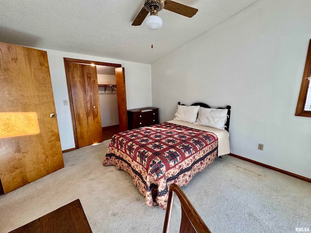 bedroom featuring a closet, light colored carpet, ceiling fan, and a textured ceiling