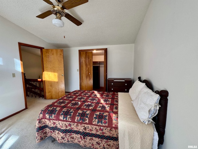 bedroom featuring lofted ceiling, a textured ceiling, light carpet, a ceiling fan, and baseboards