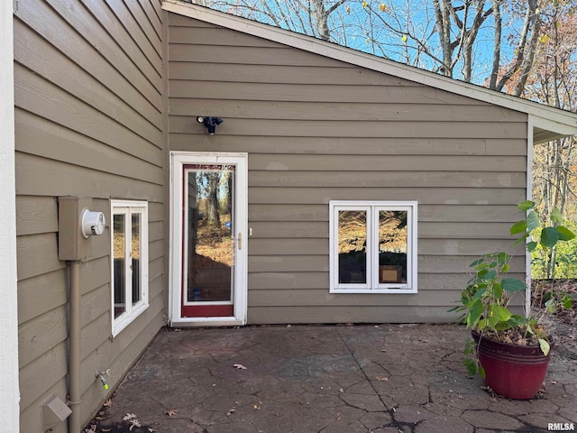 view of exterior entry with a patio area