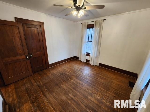 unfurnished bedroom featuring crown molding, ceiling fan, and dark wood-type flooring