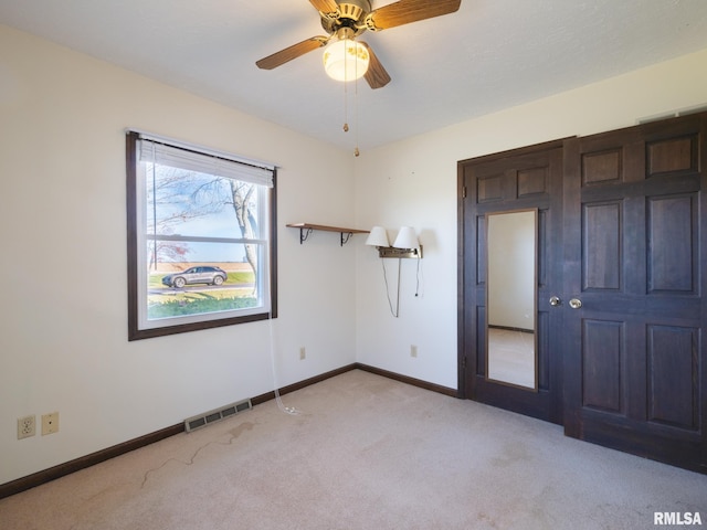 carpeted empty room featuring ceiling fan