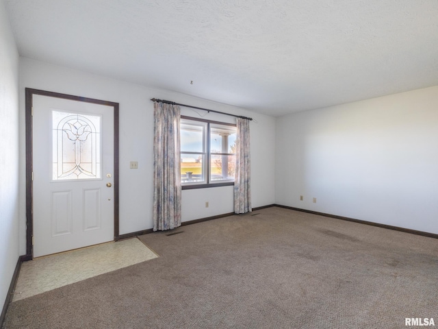 carpeted entrance foyer featuring a textured ceiling