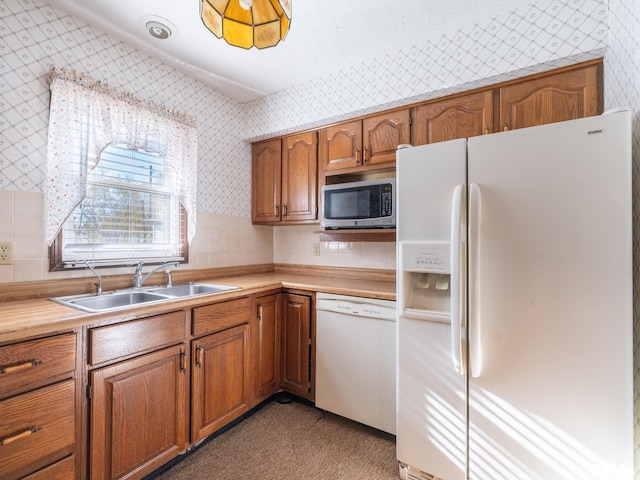 kitchen with white appliances, light colored carpet, and sink