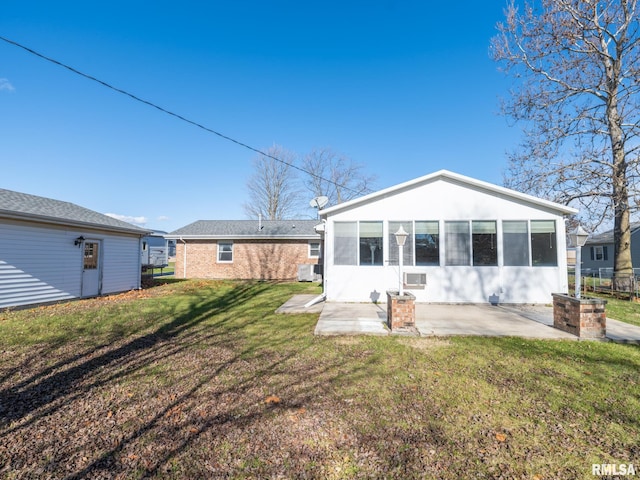 back of house featuring a yard, a patio area, and a sunroom