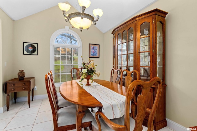 dining space with light tile patterned floors, lofted ceiling, and a notable chandelier